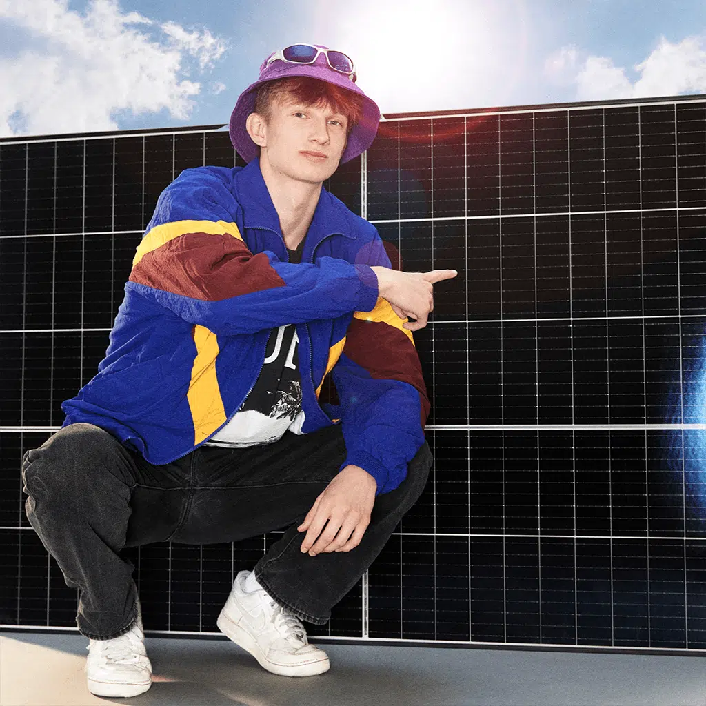 Junger Mann sitzt auf einem Batteriespeicher.